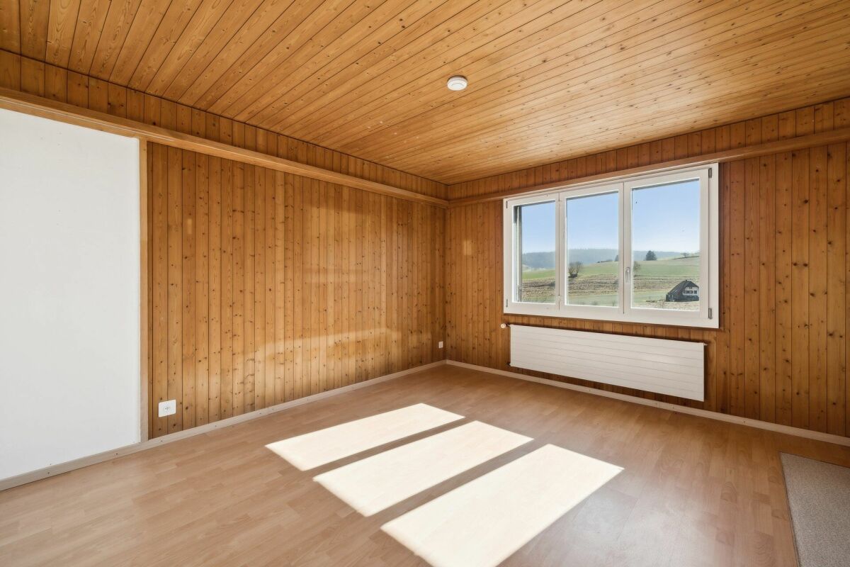 Holzvertäfelter leerer Raum mit Fenster