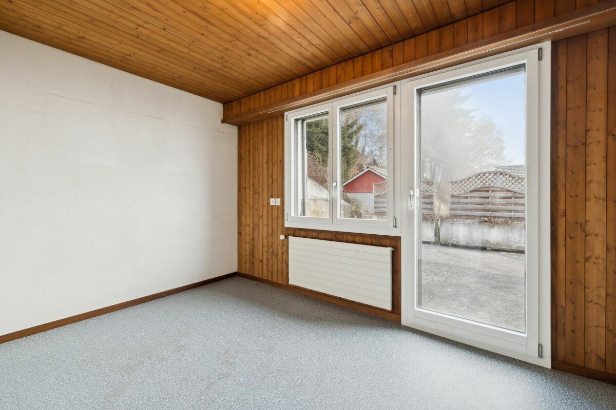 Leerer Raum mit Holzdecke und Terrassentür
