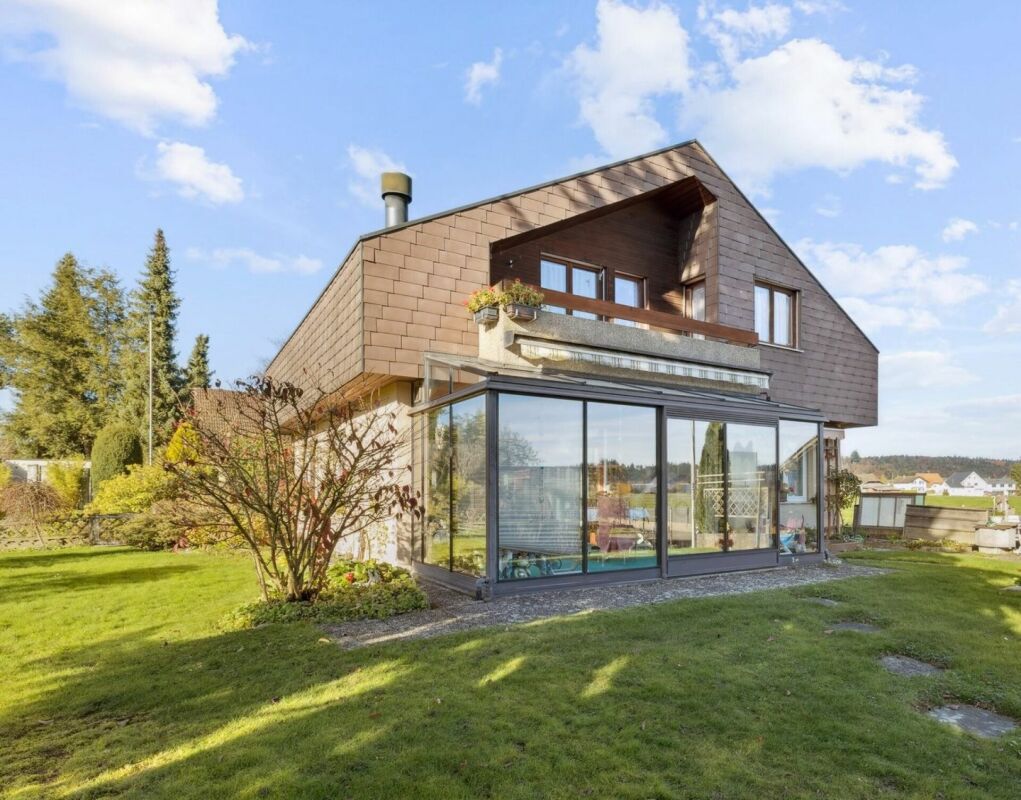 Modernes Einfamilienhaus mit Wintergarten und Gartenansicht