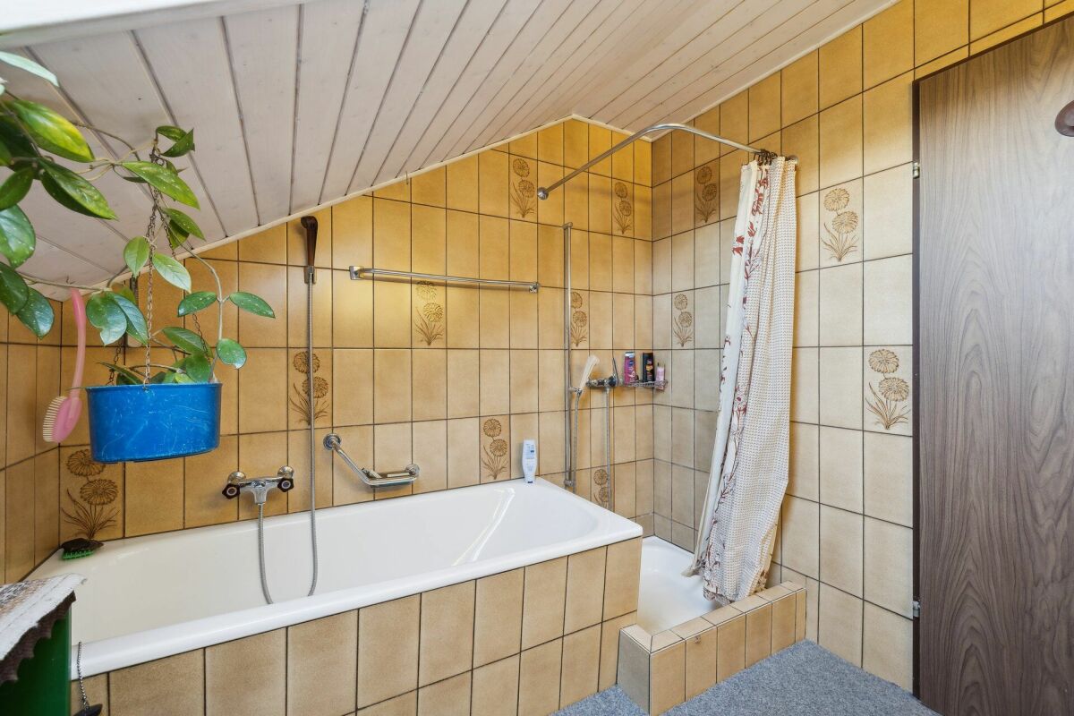 Badezimmer mit Badewanne und Duschbereich