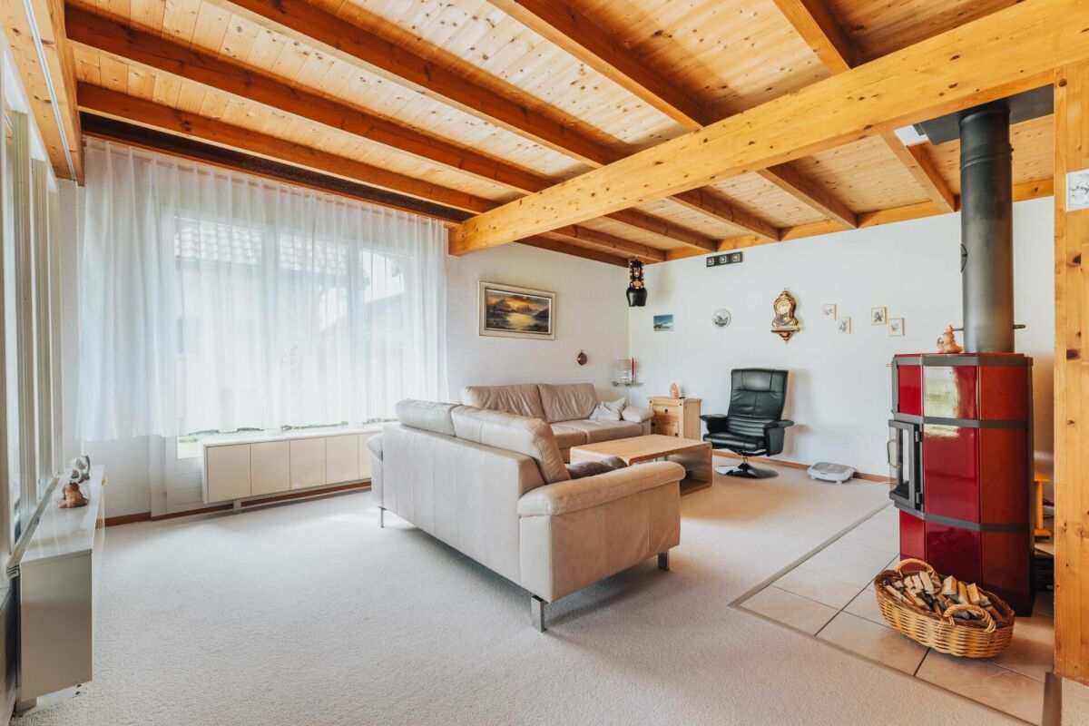 Wohnzimmer mit Holzbalkendecke und Kaminofen