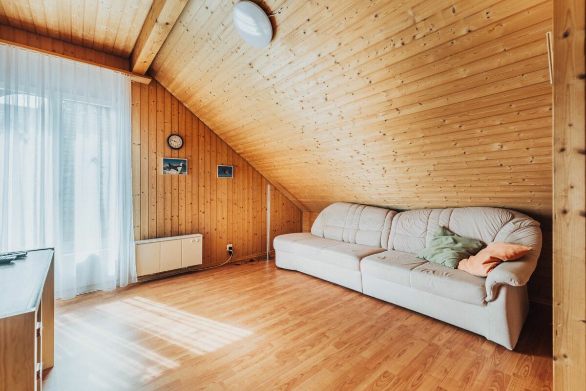 Dachzimmer mit Holzverkleidung und Sofa