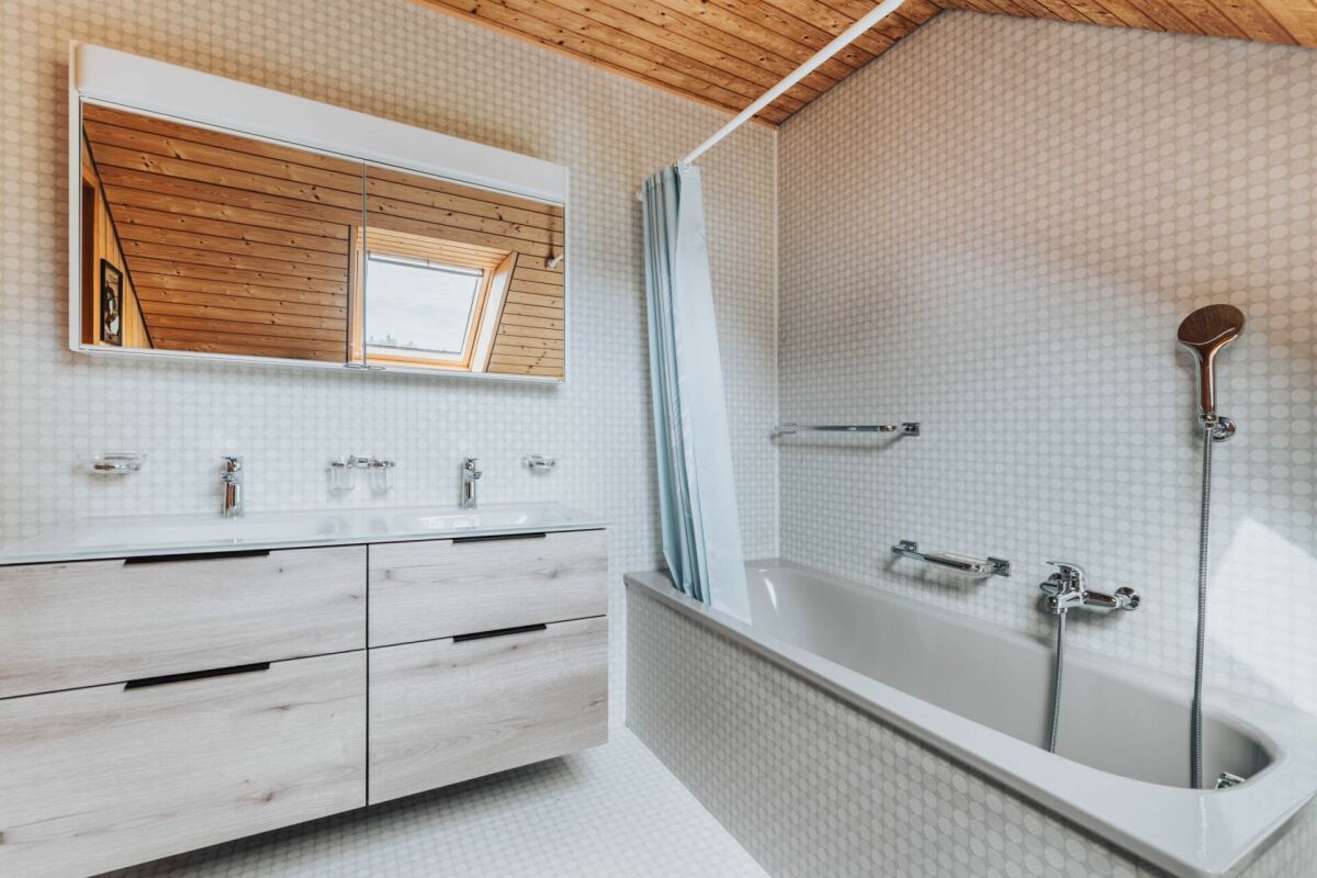 Badezimmer mit Wanne und Holzdecke