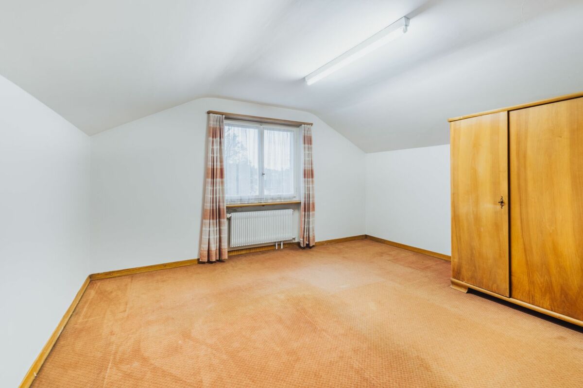 Dachzimmer mit Fenster und Kleiderschrank