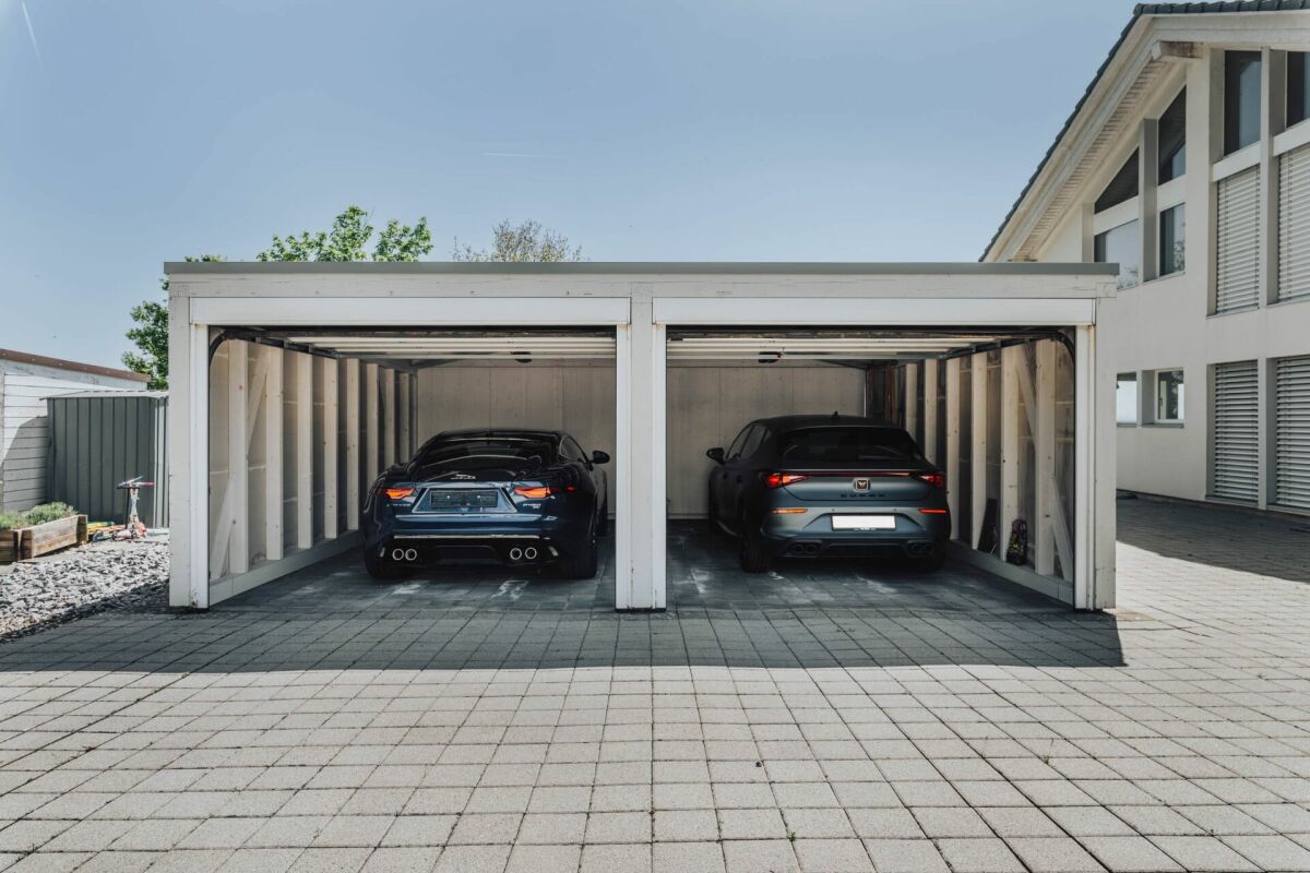 Doppelgarage mit zwei Autos vor einem Wohnhaus