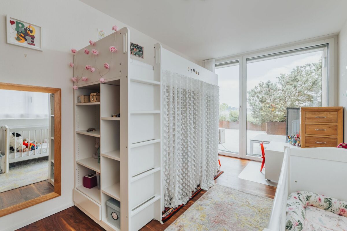 Kinderzimmer mit großem Fenster und Spielbereich
