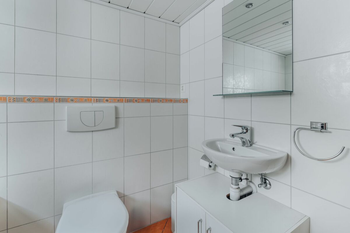 Gäste-WC mit Wandfliesen und Waschbecken