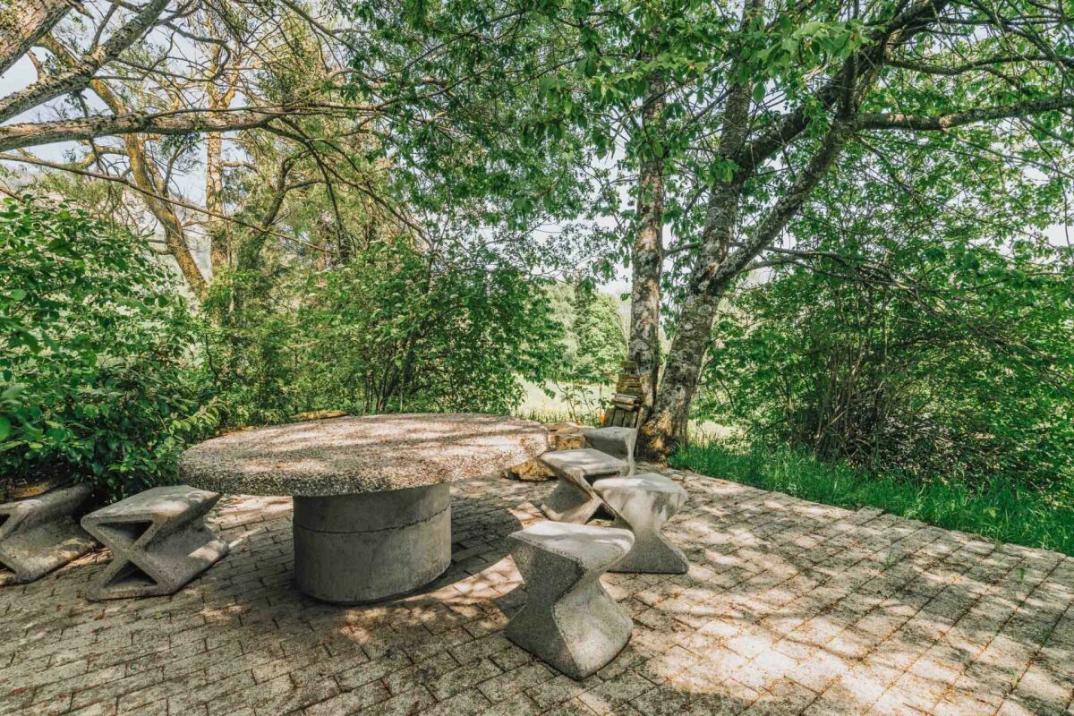 Gartenpatio mit Steintisch und Sitzbänken