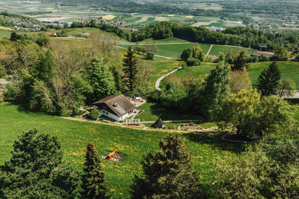 Luftaufnahme eines Hauses in grüner Hügellandschaft