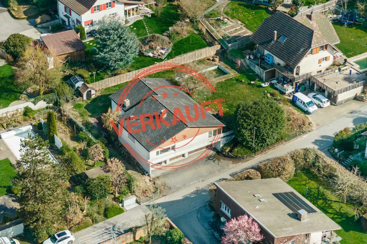 Luftaufnahme eines Wohnhauses mit rotem „VERKAUFT“-Stempel