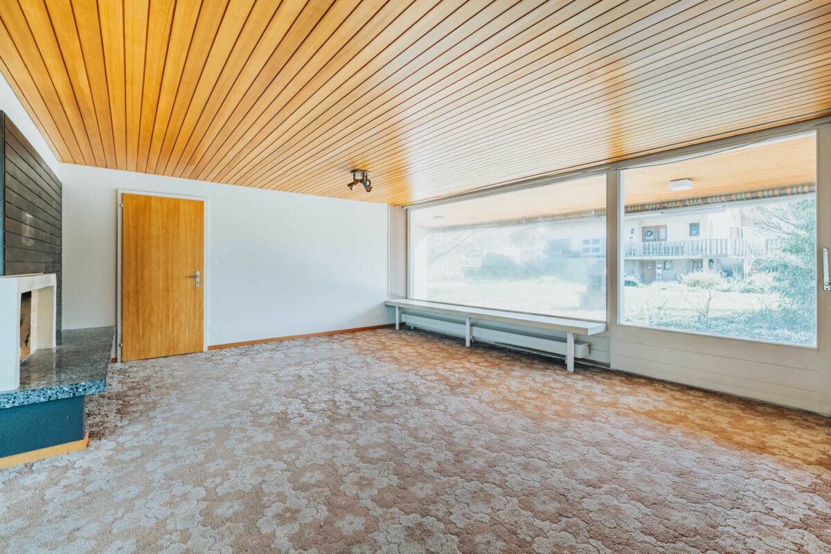 Wohnzimmer mit Kamin und großer Fensterfront