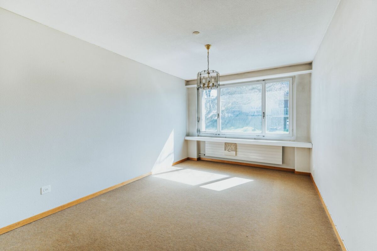 Helles, leeres Zimmer mit großem Fenster