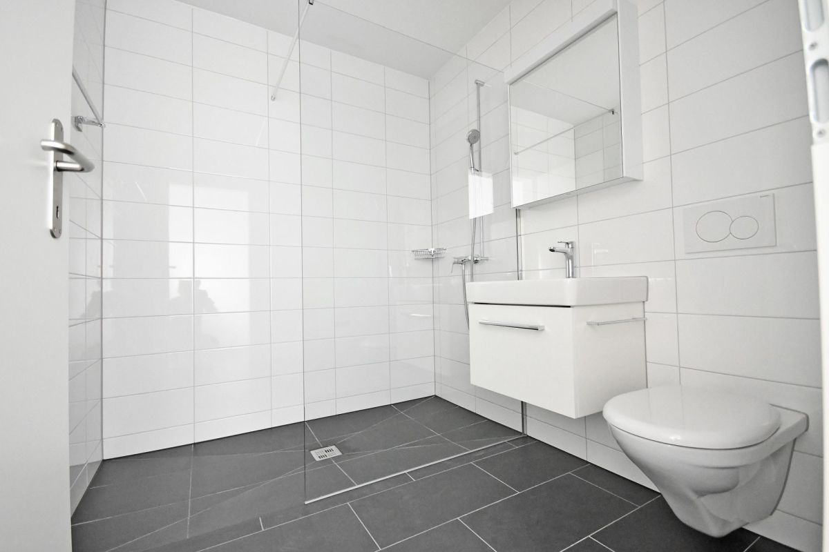 Modernes Badezimmer mit bodengleicher Dusche und WC