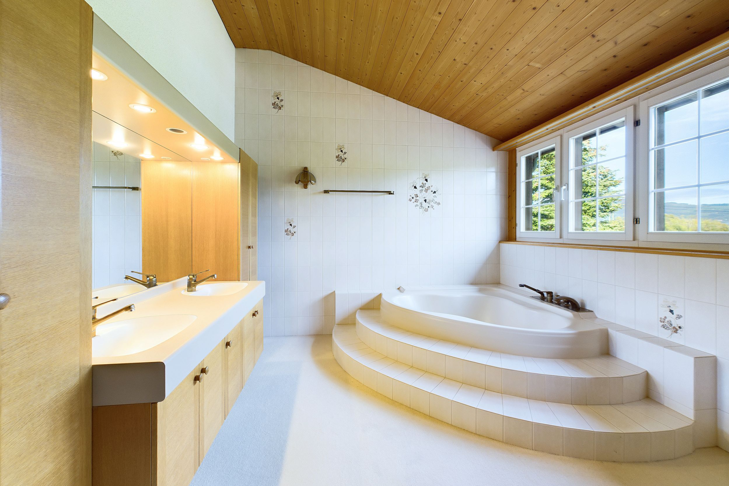 Helles Bad mit Holzdecke und Whirlpoolwanne