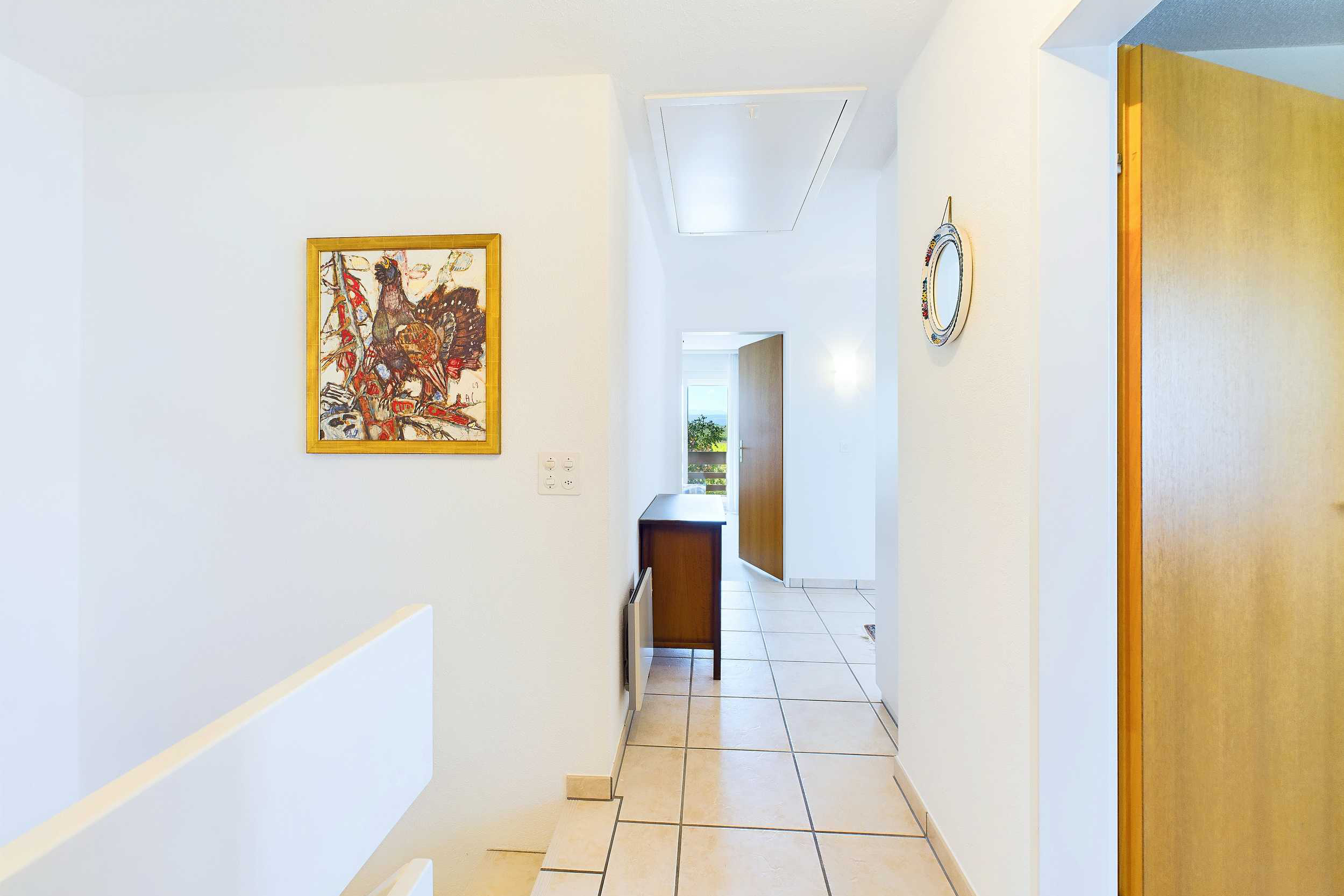 Heller Flur mit Treppe und Holz­türen
