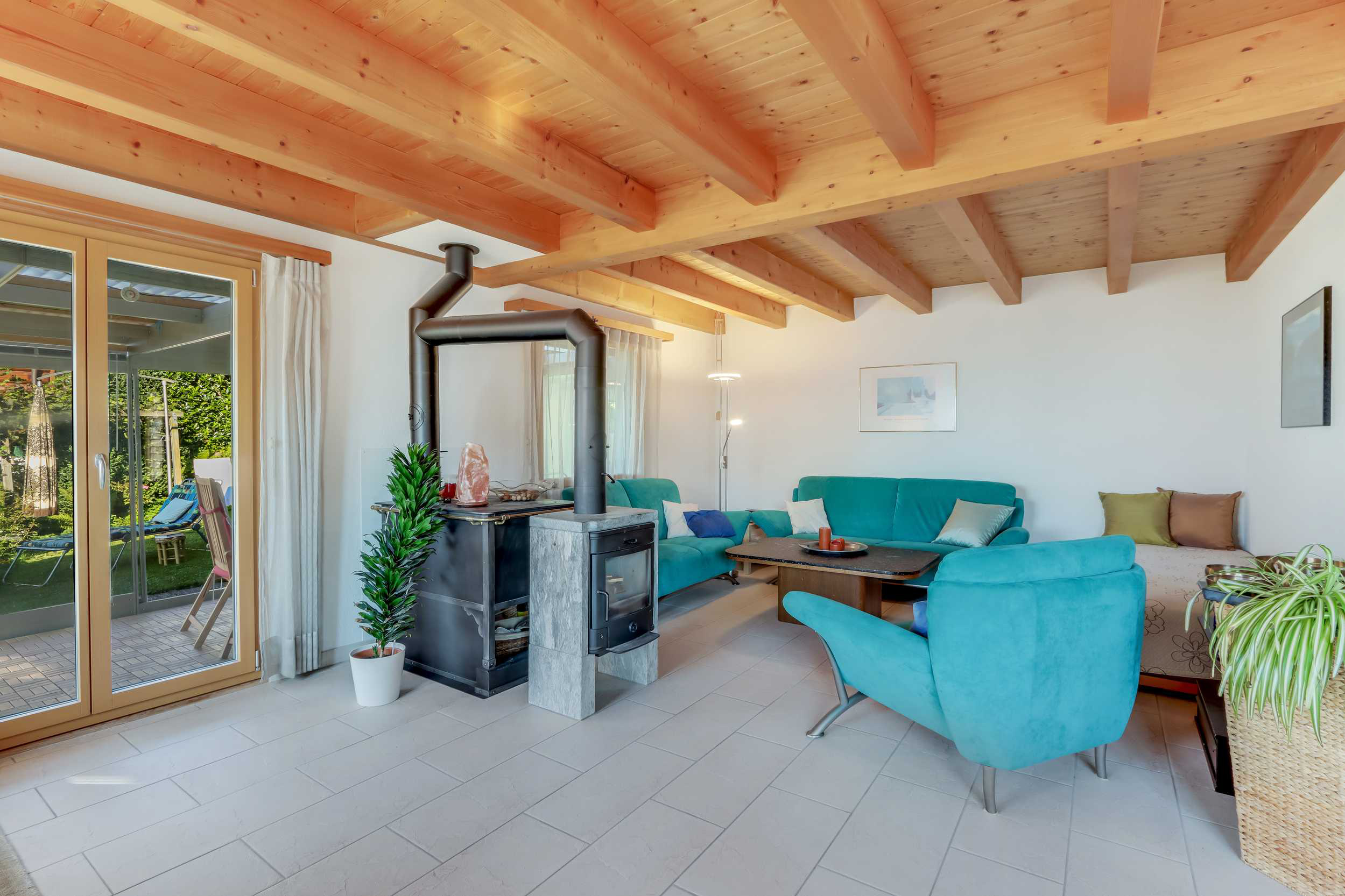 Heller Wohnraum mit Kaminofen und Holzdecke