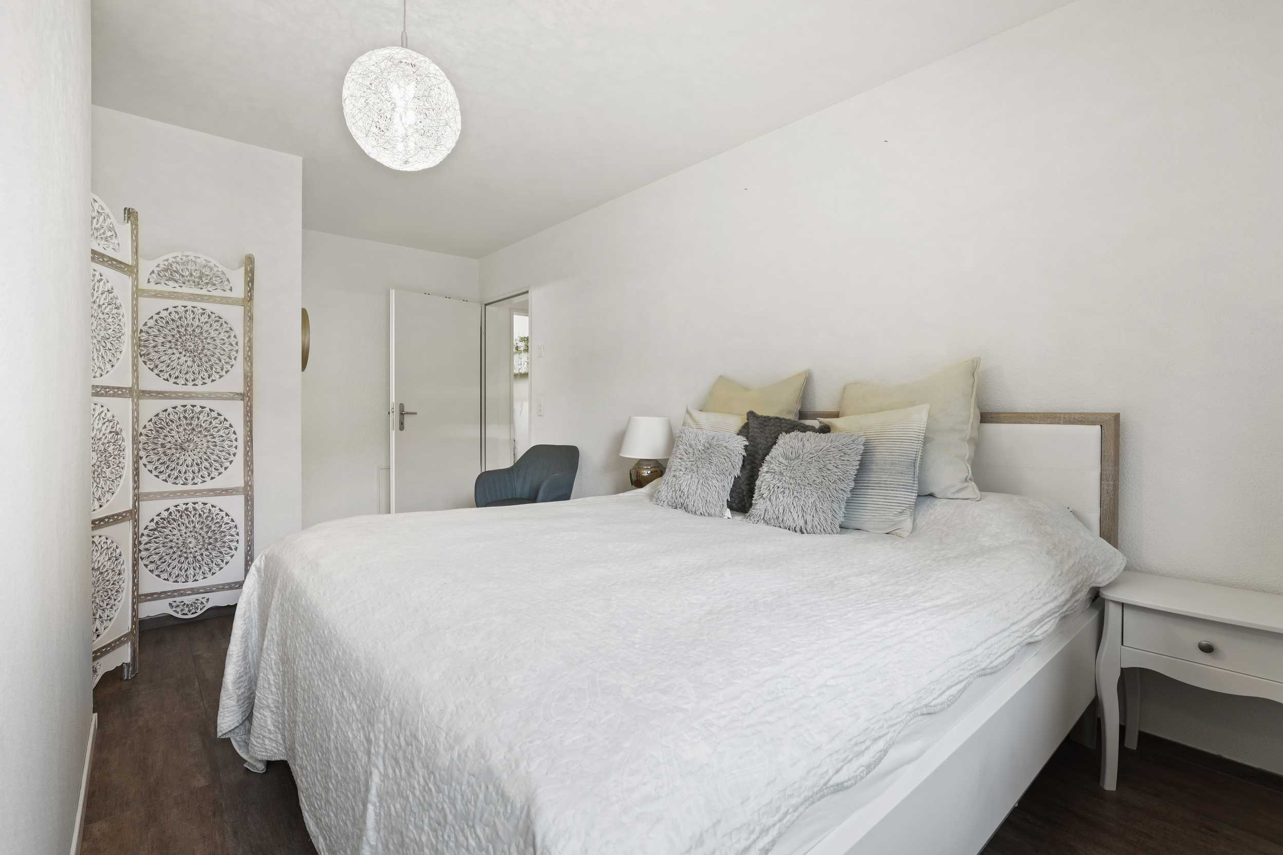 Helles Schlafzimmer mit weißem Bett und Deko