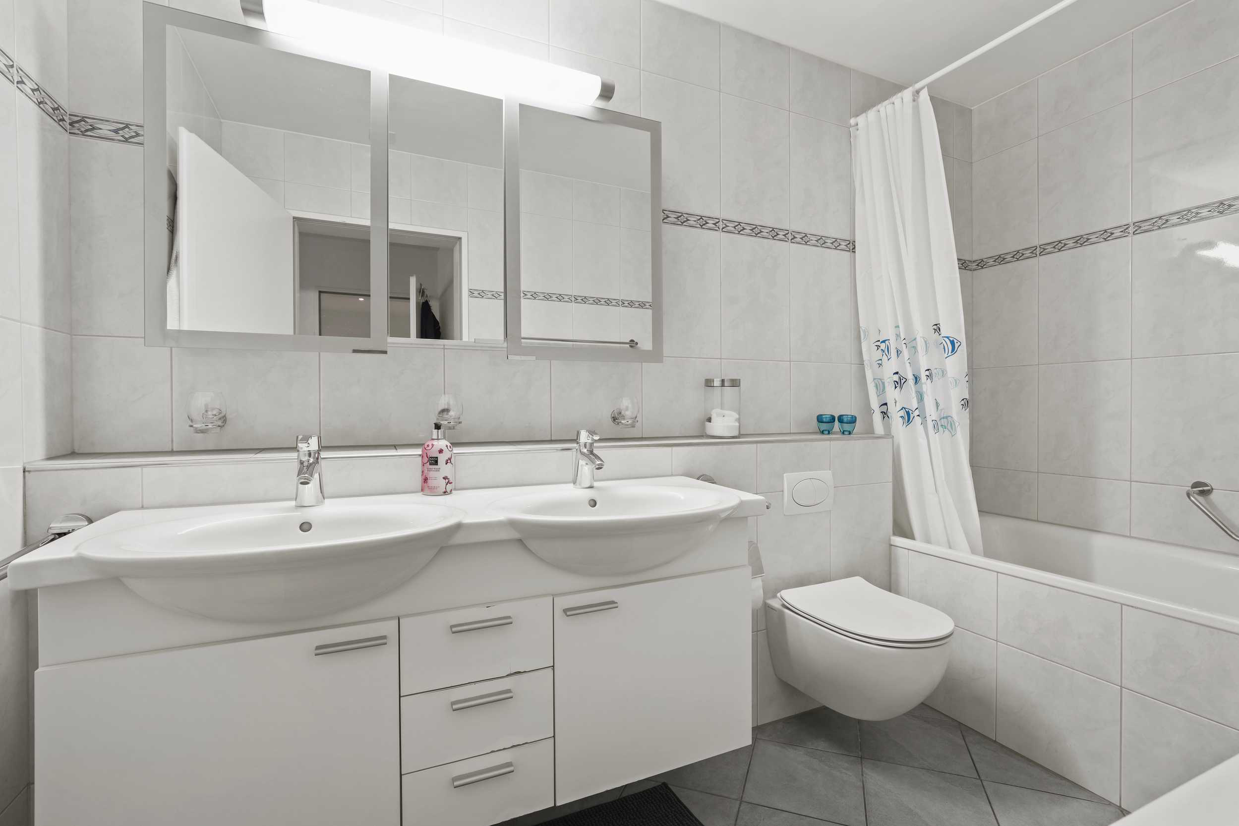 Helles Badezimmer mit Doppelwaschtisch und Badewanne