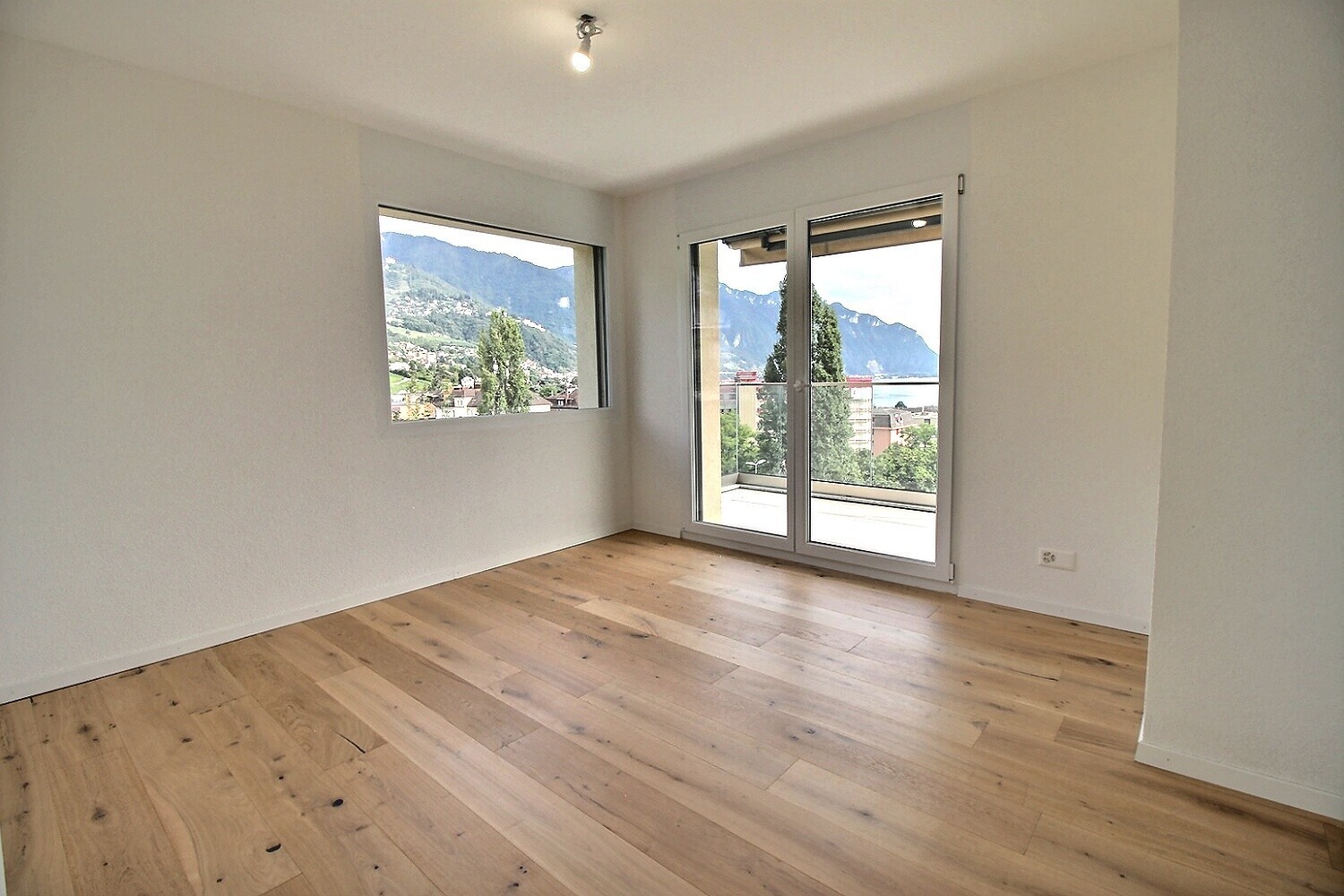Heller Raum mit Holzparkett und Bergblick