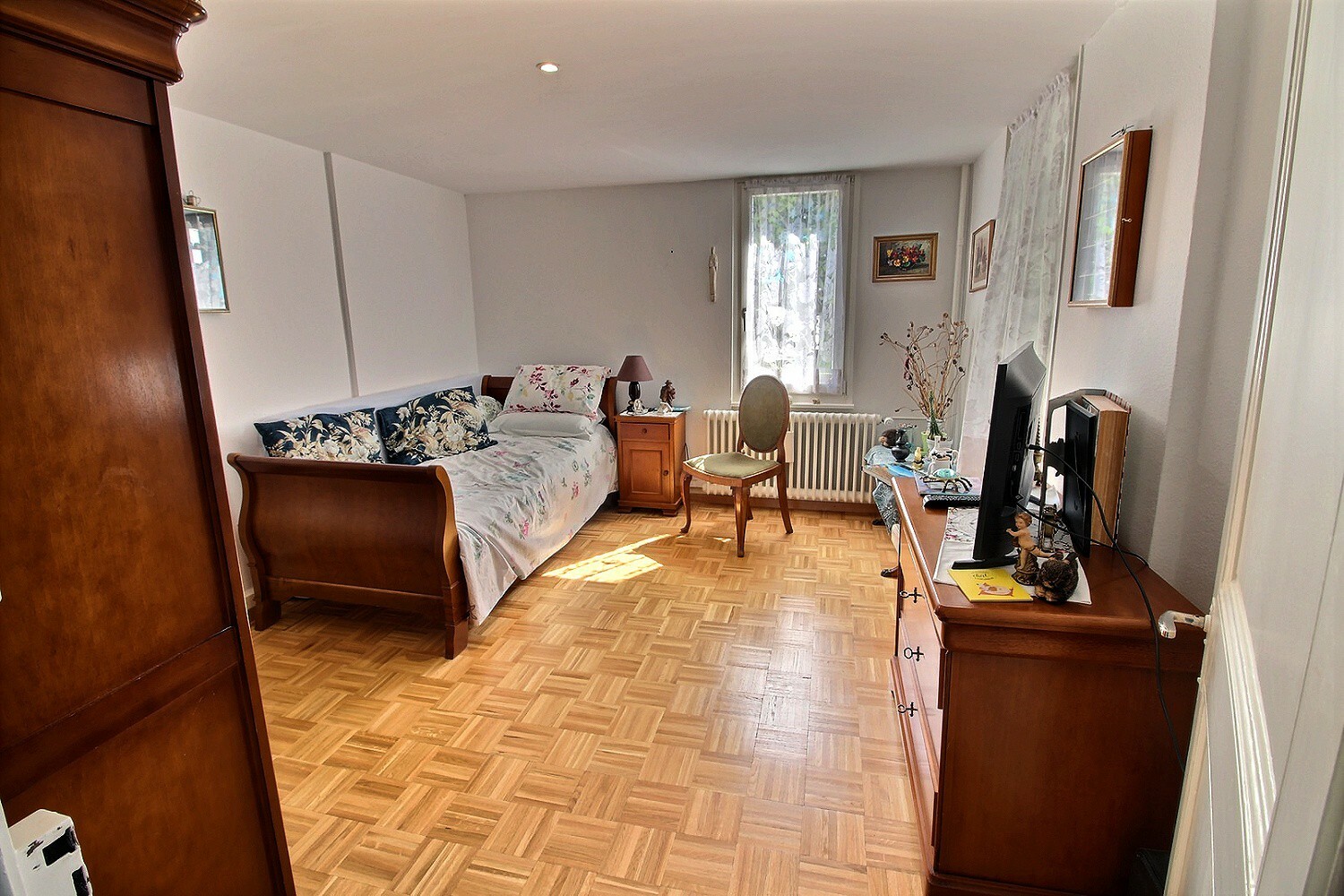 Helles Schlafzimmer mit Holzmöbeln und Parkettboden