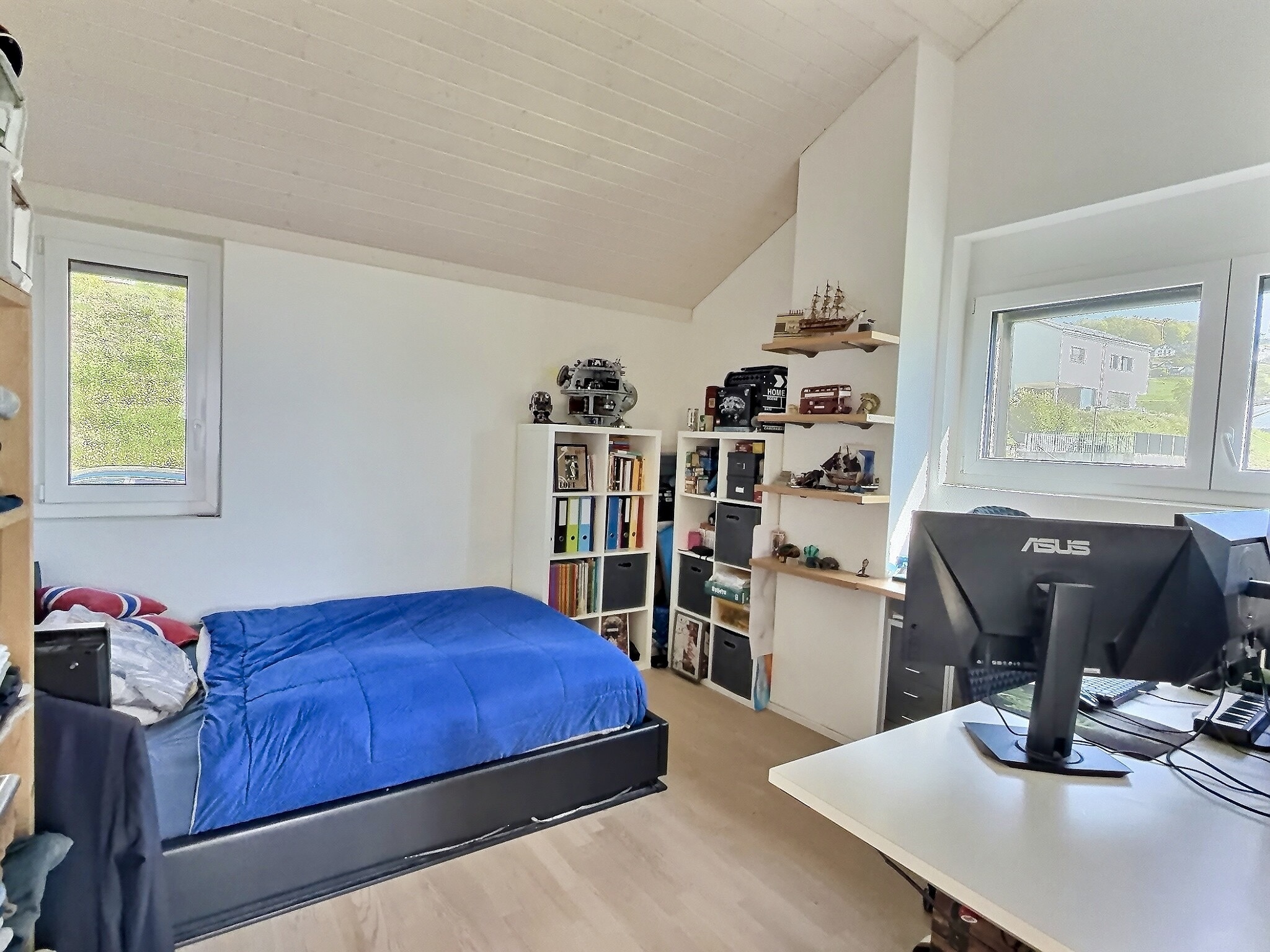 Helles Dachzimmer mit Bett und Arbeitsbereich
