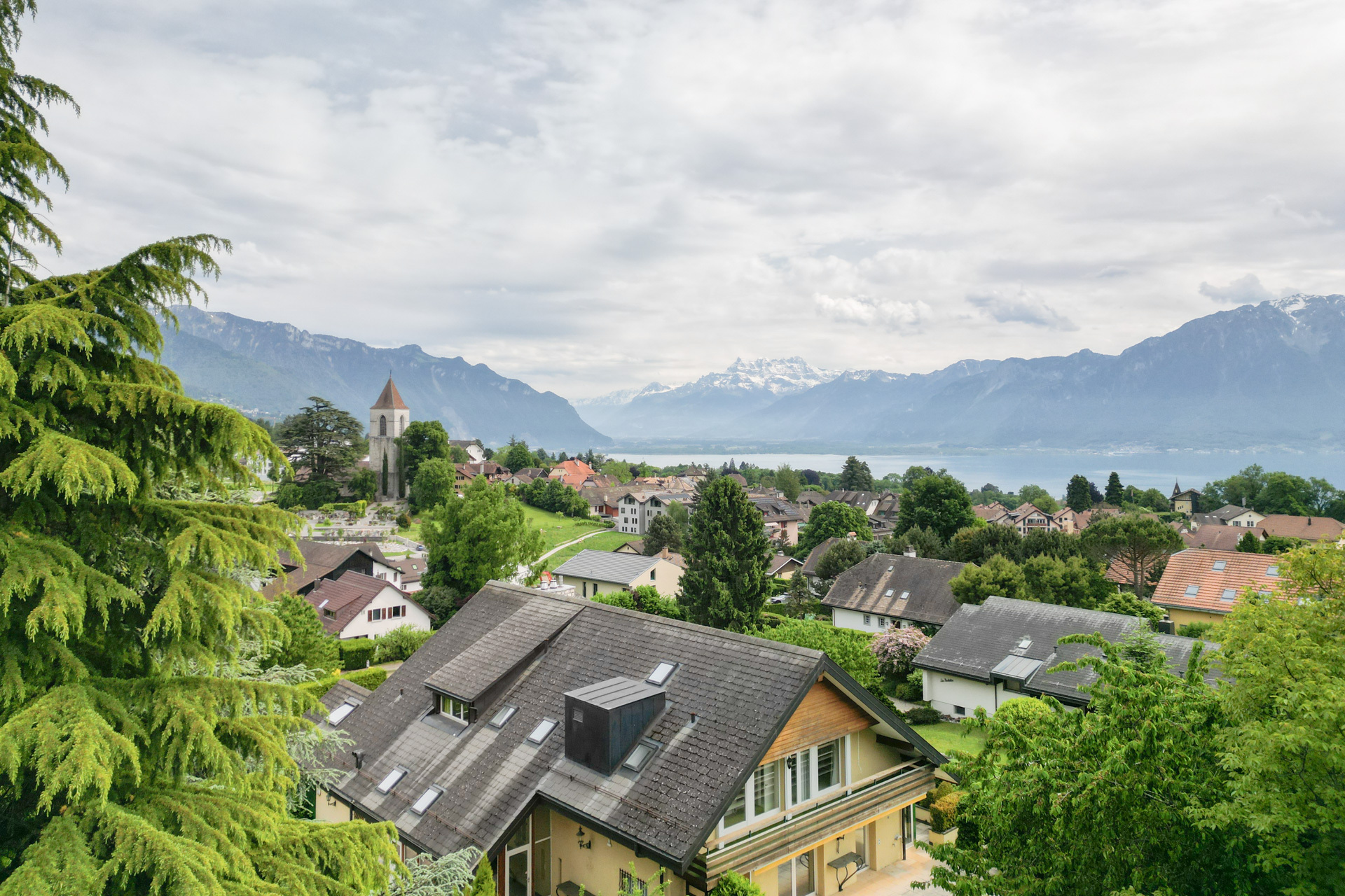 Landschaftsblick über Wohnhäuser zum See und in die Berge