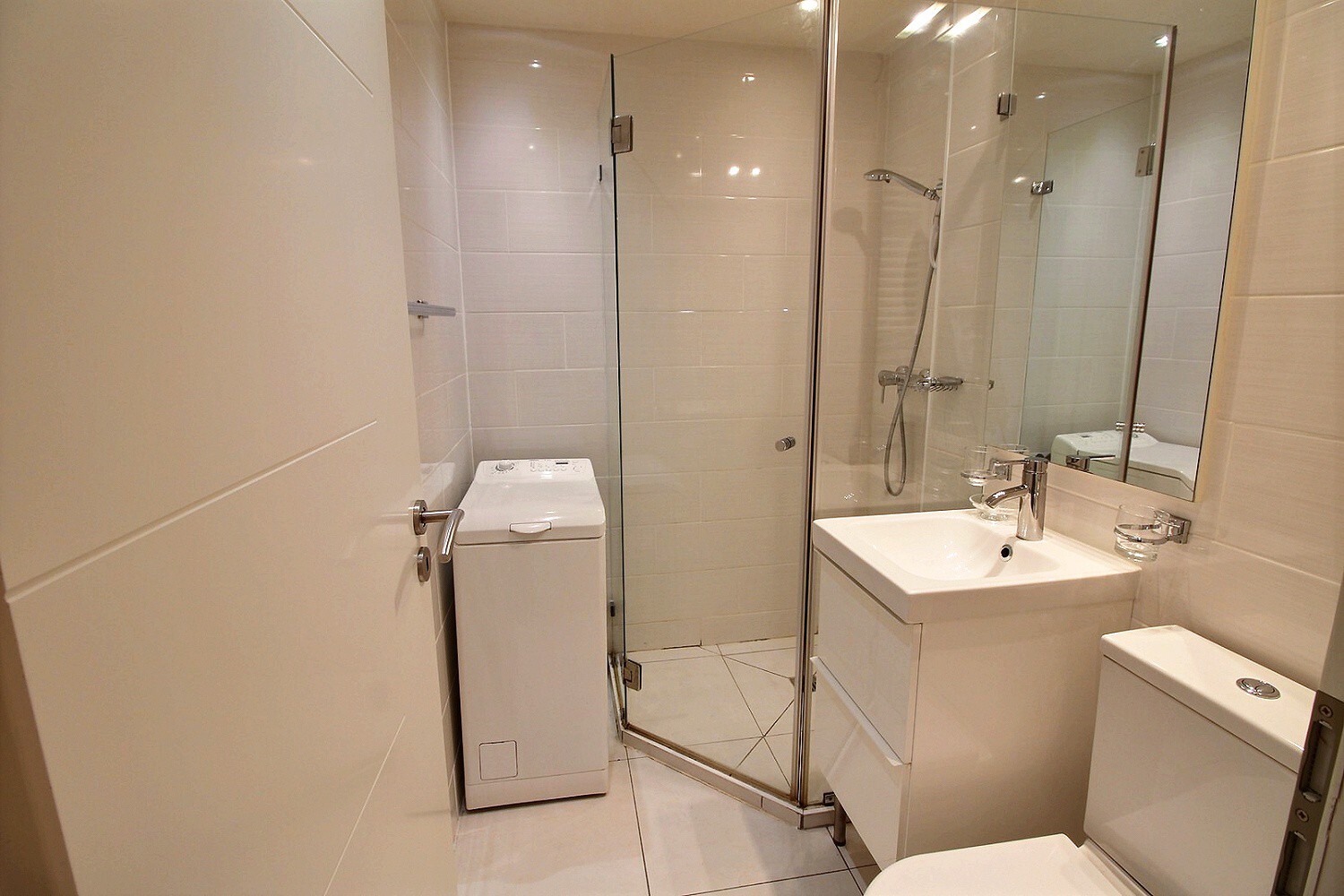 Modernes Badezimmer mit Dusche und Waschmaschinenbereich