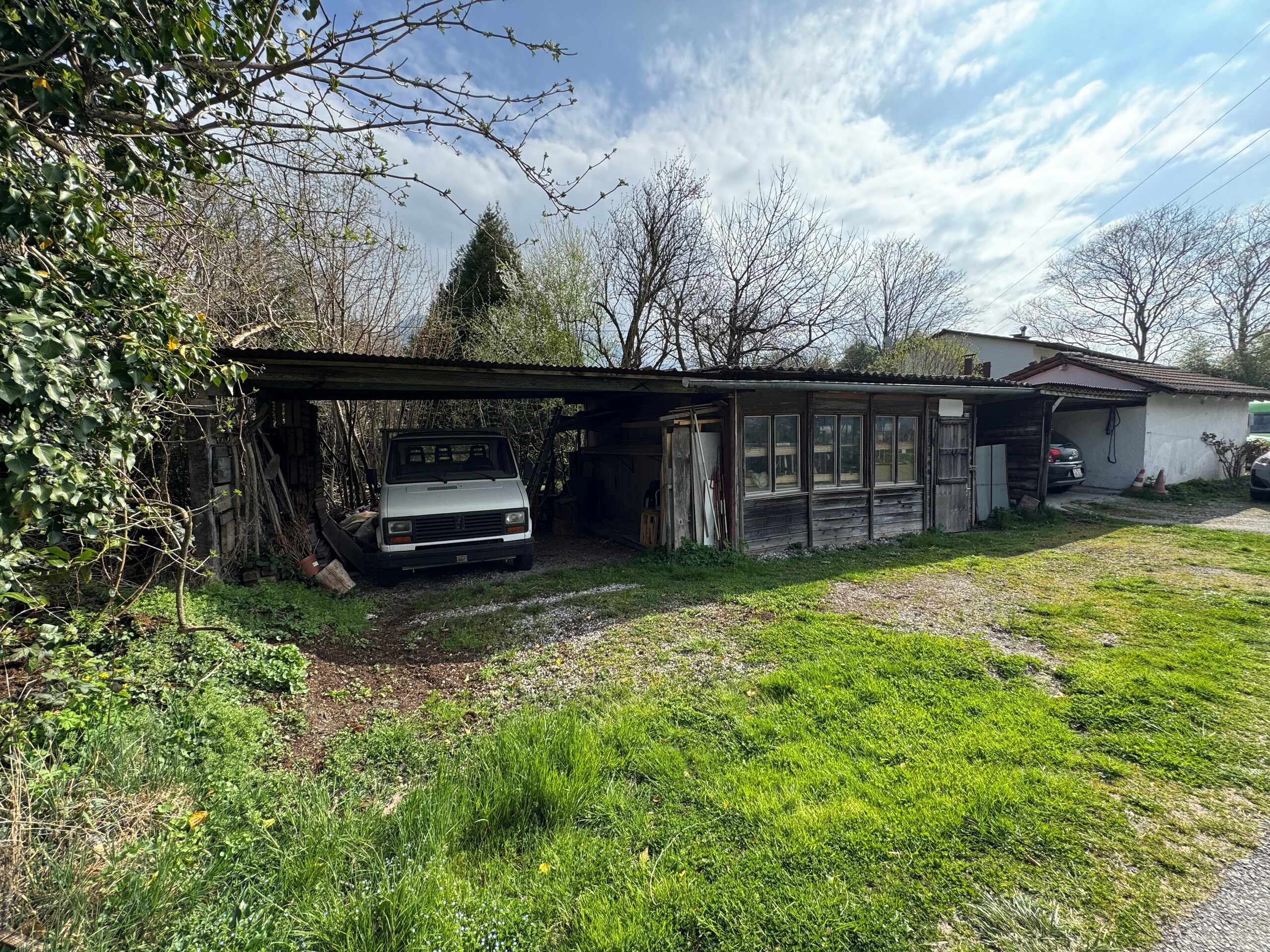 Rustikales Nebengebäude mit Carport im Grünen
