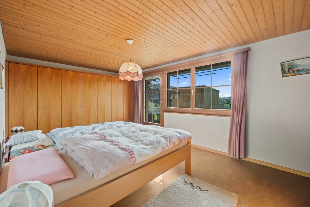 Schlafzimmer mit Holzdecke und großen Fenstern