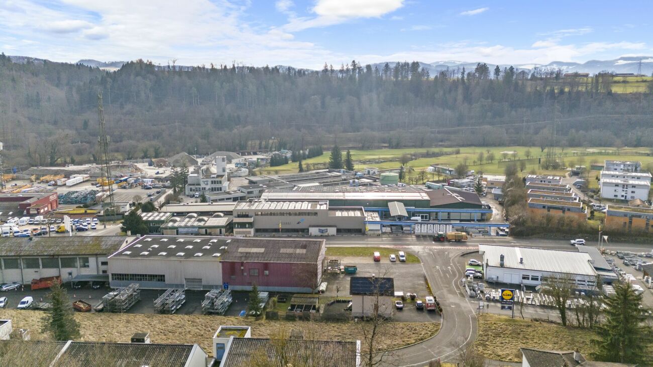 Luftaufnahme eines Gewerbegebiets mit Landschaft im Hintergrund