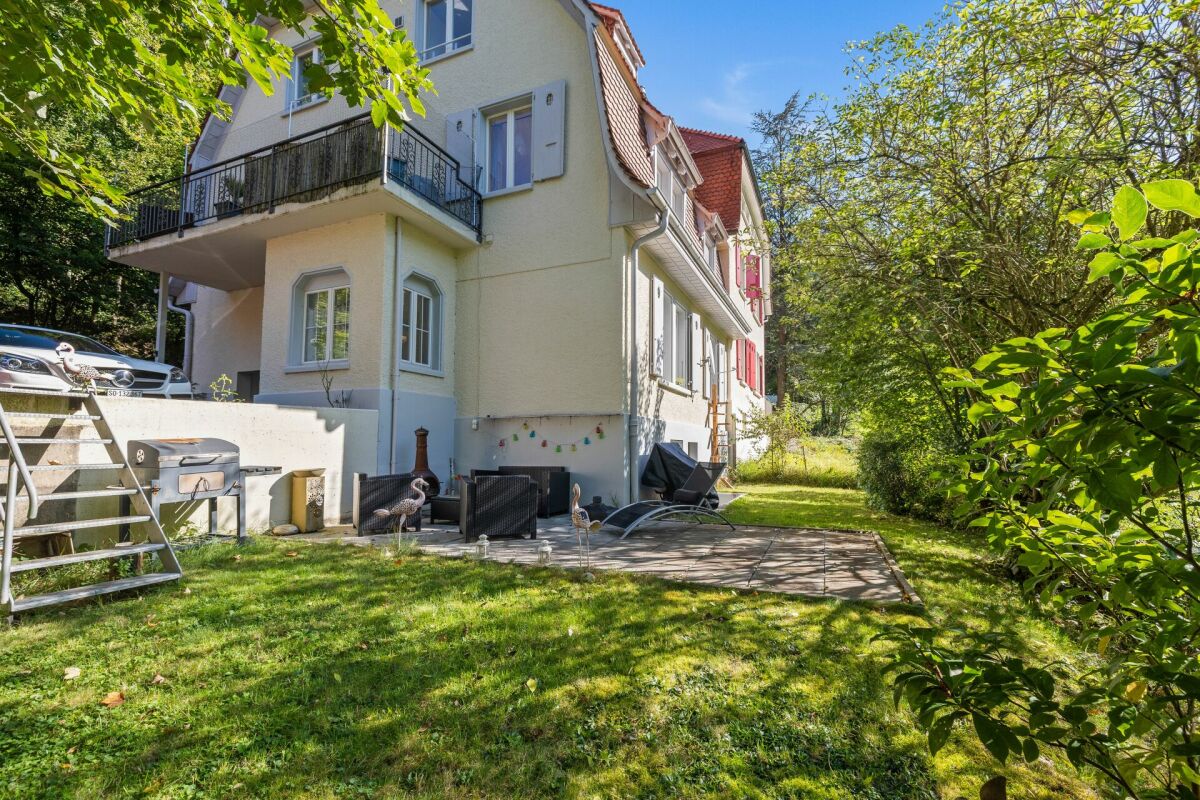 Gartenansicht eines Wohnhauses mit Terrasse und Balkon