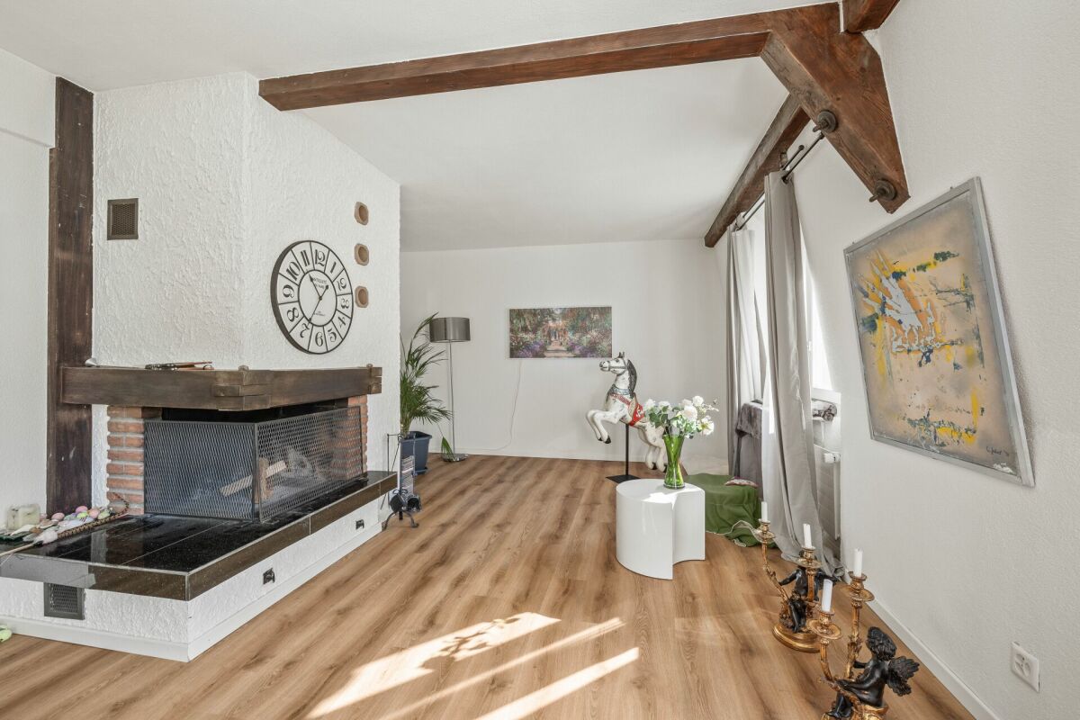 Wohnzimmer mit Kamin und sichtbaren Holzbalken