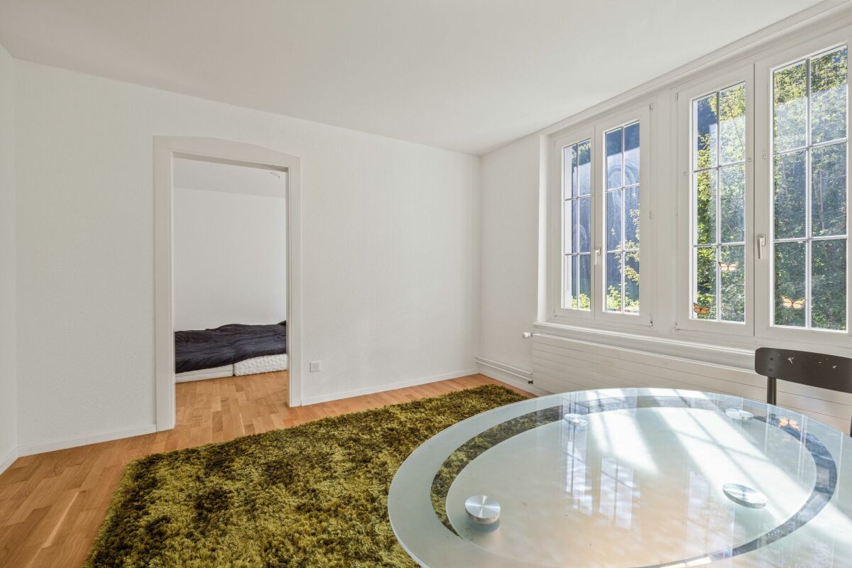 Helles Zimmer mit großem Fenster und Glasstisch