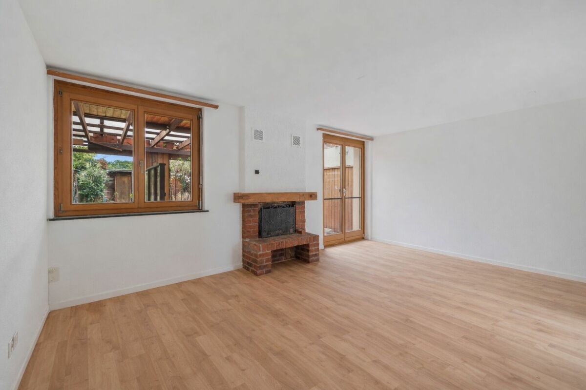 Heller Wohnraum mit Kamin und Holztüren