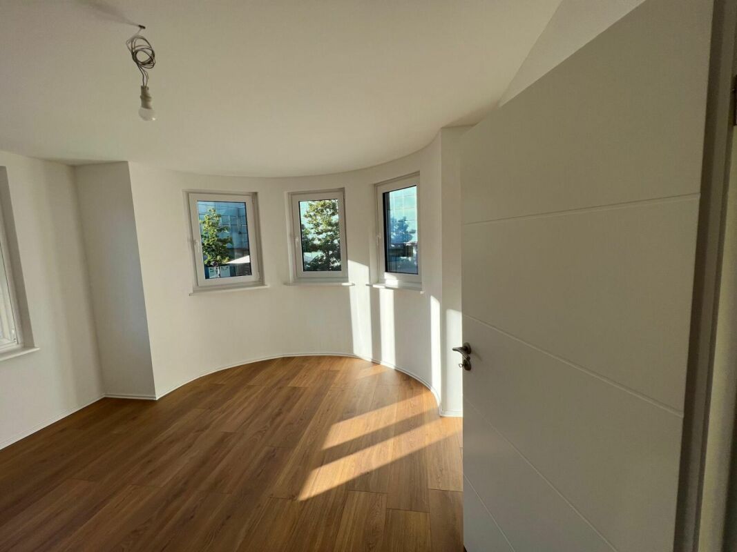 Heller leerer Raum mit halbrunder Fensterfront