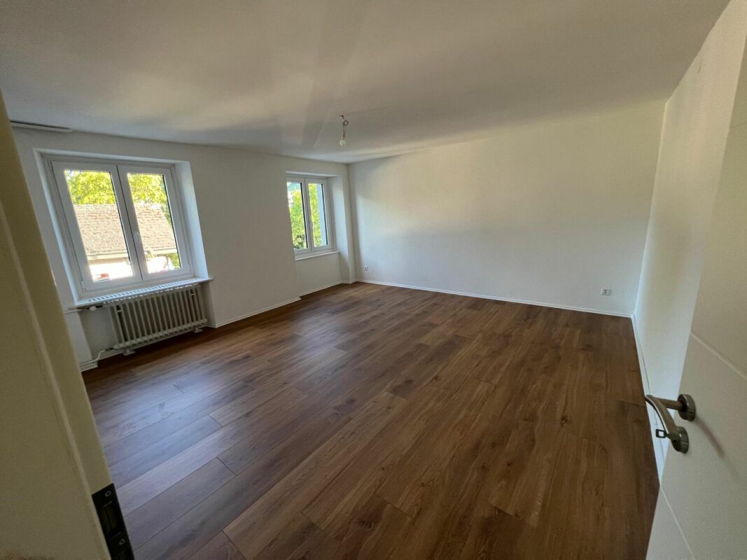 Leerer heller Wohnraum mit Parkettboden