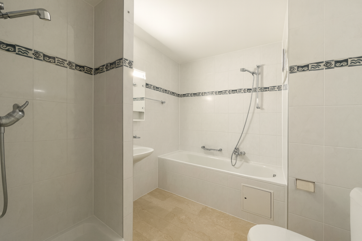 Badezimmer mit Wanne und Duschbereich