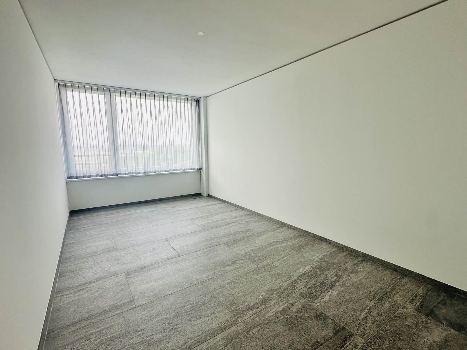 Leerer, modern gestalteter Raum mit großem Fenster