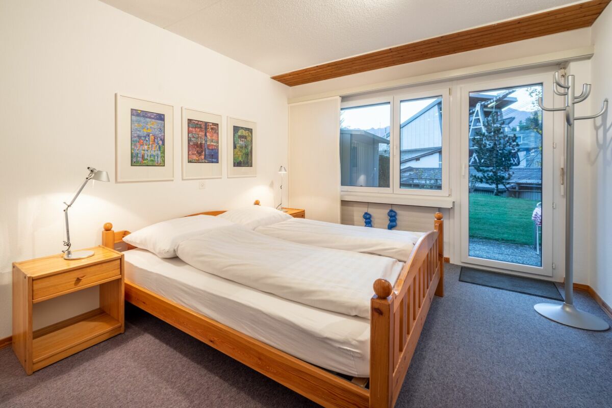 Helles Schlafzimmer mit Doppelbett und Gartenzugang