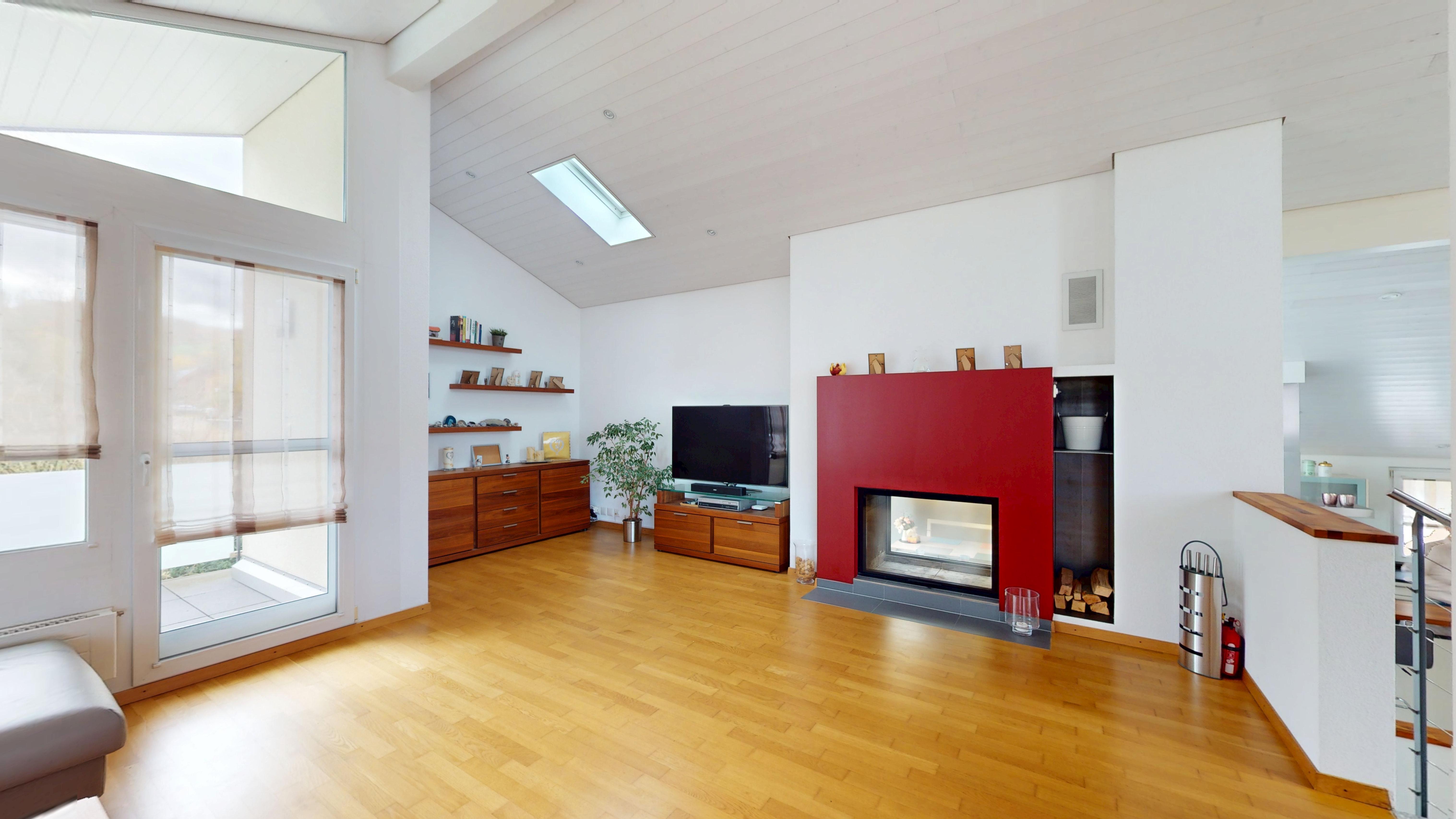 Helles Wohnzimmer mit Kamin und Holzfußboden