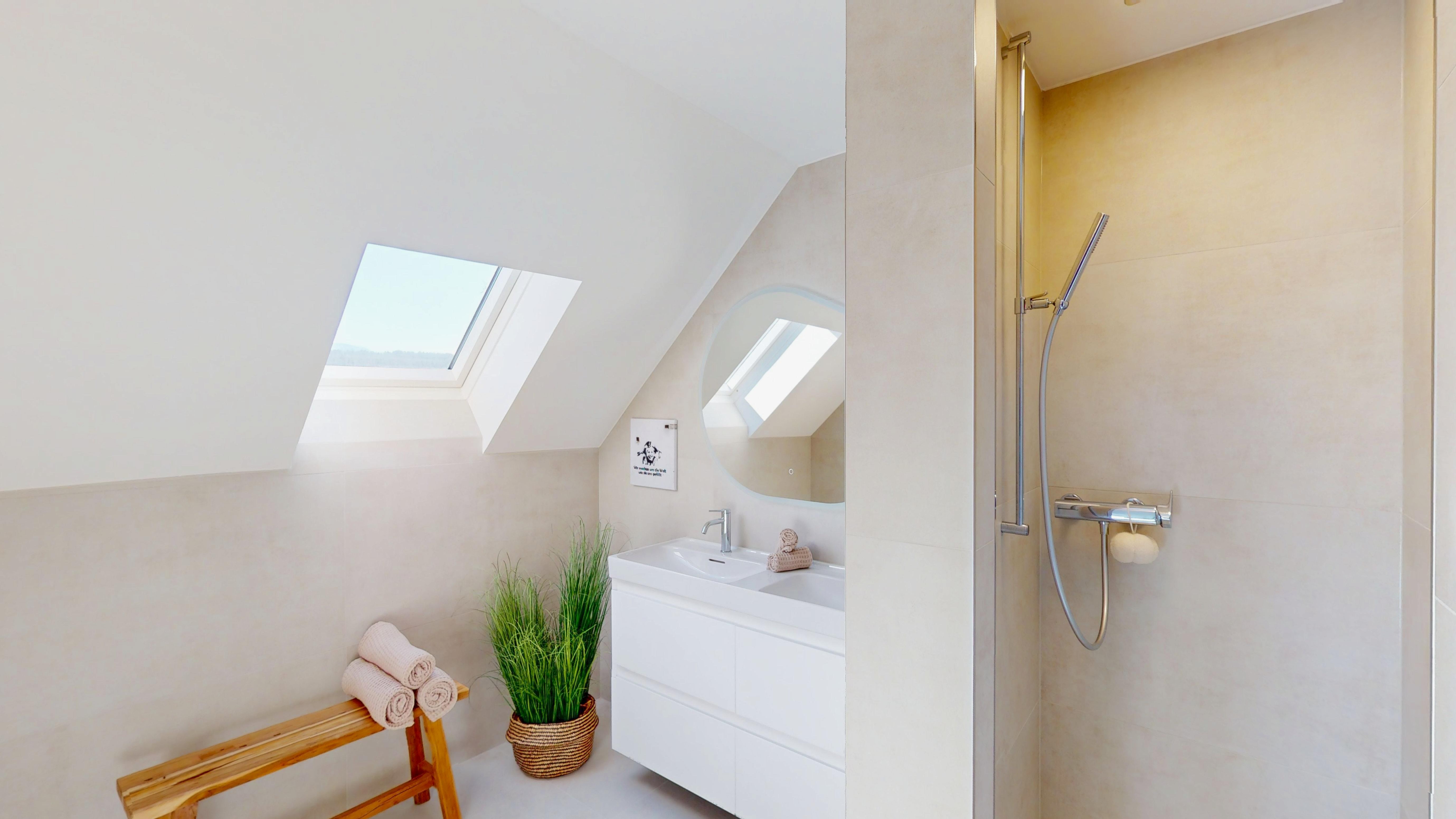 Helles Dachgeschoss-Badezimmer mit Dusche und Waschtisch