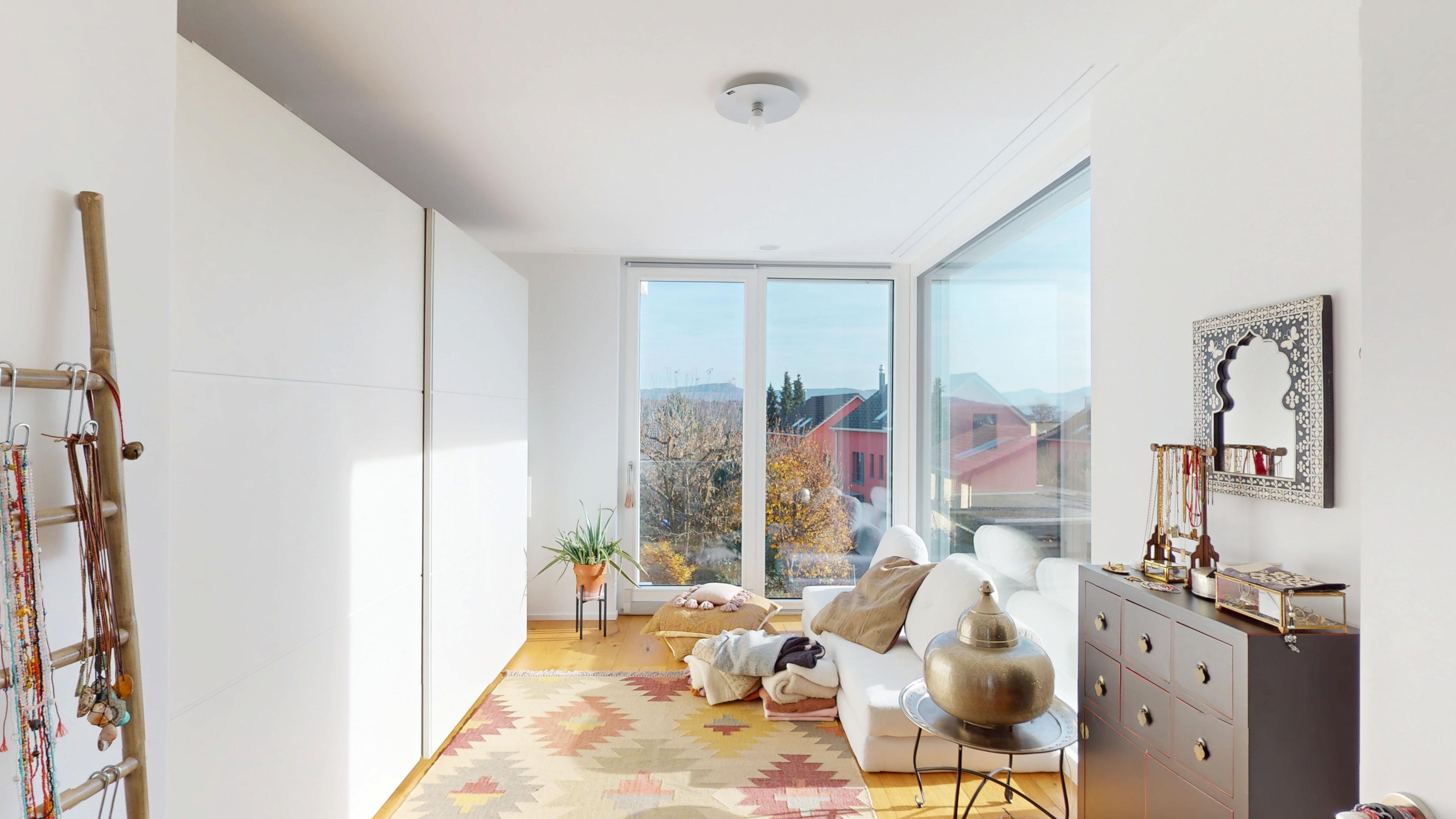 Heller Wohnraum mit Sitzbereich und großem Fenster