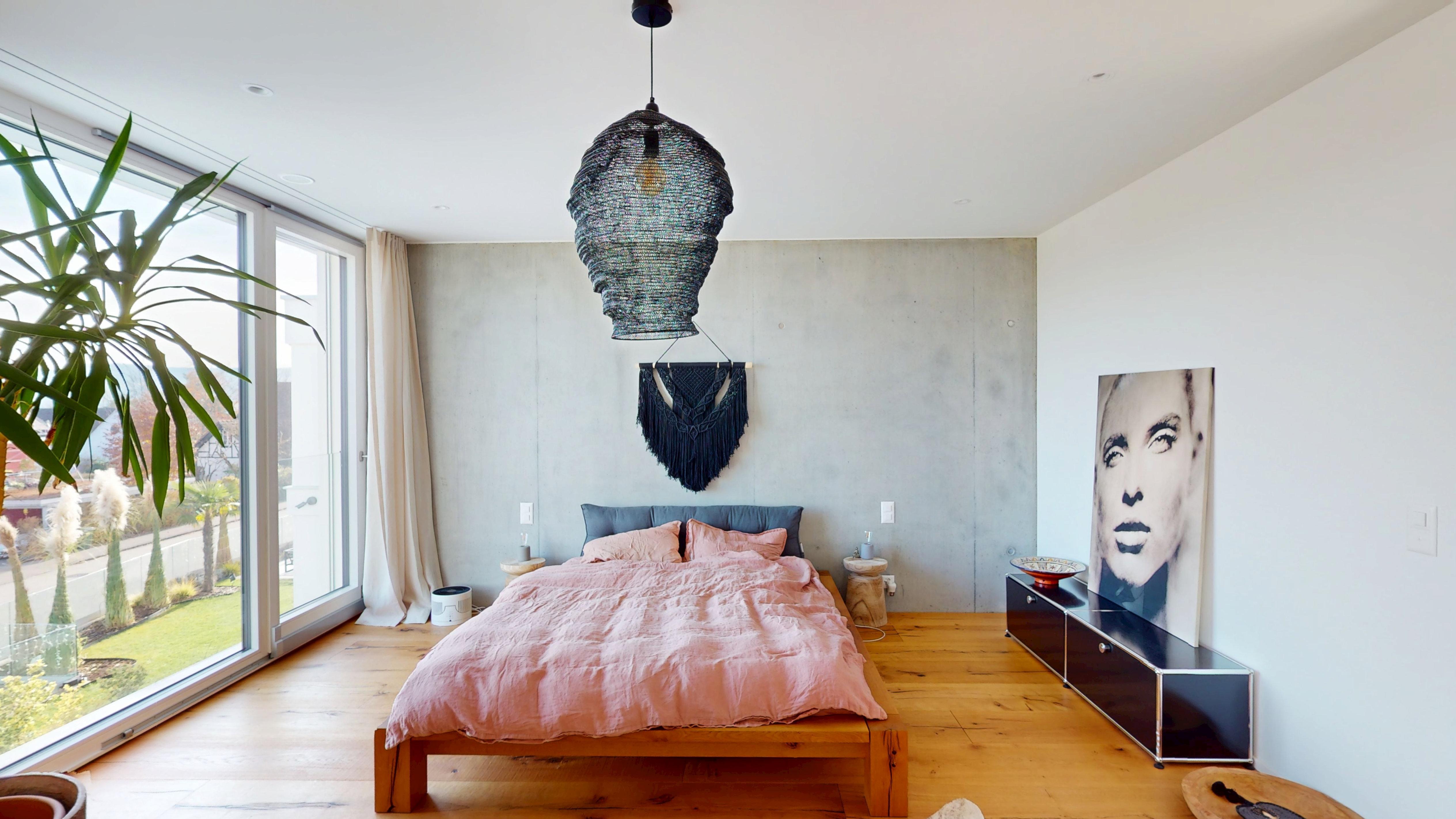 Modernes Schlafzimmer mit großen Fenstern und künstlerischer Wandgestaltung