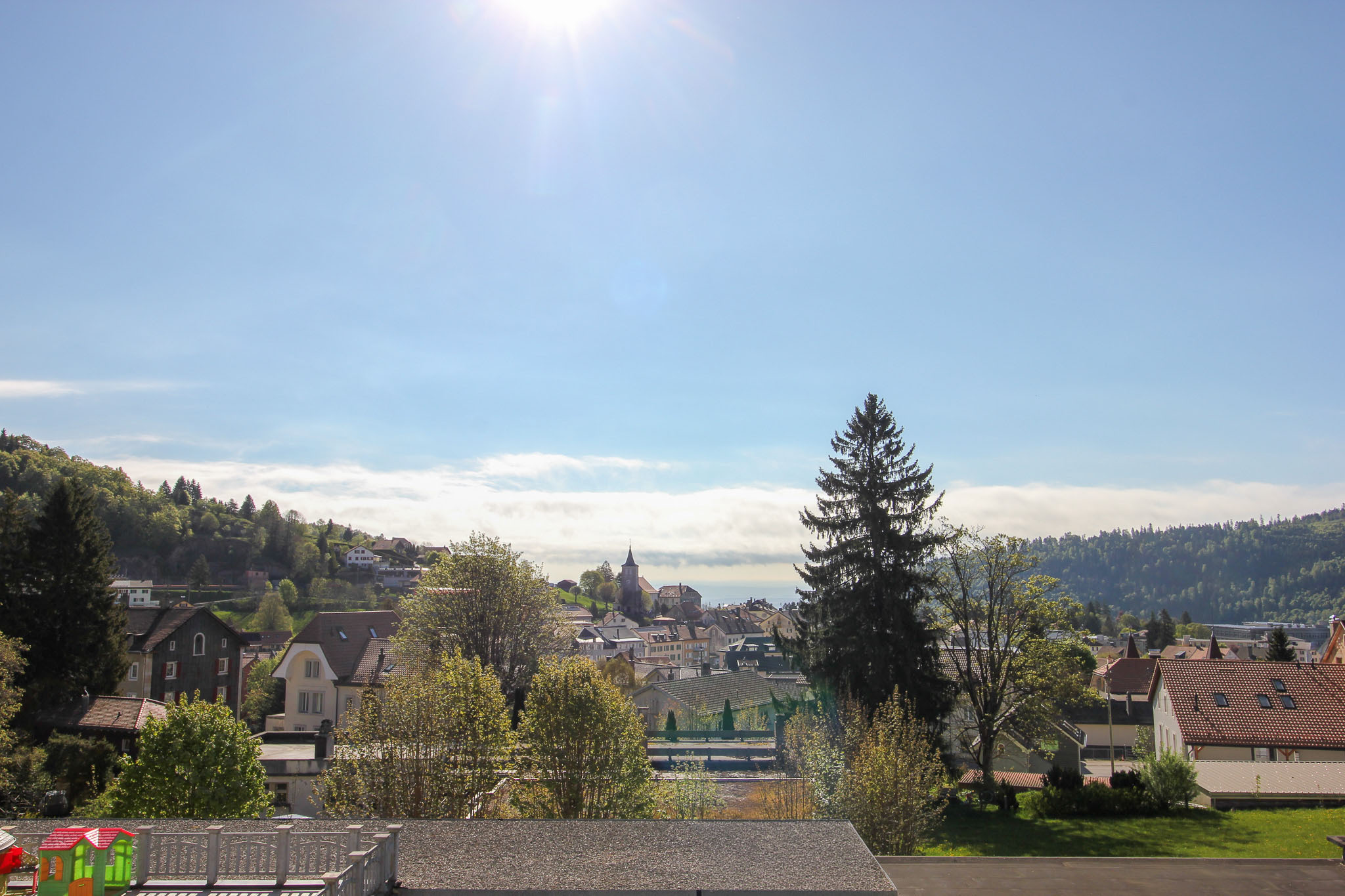 Panoramablick über eine Ortschaft mit Tal- und Bergkulisse