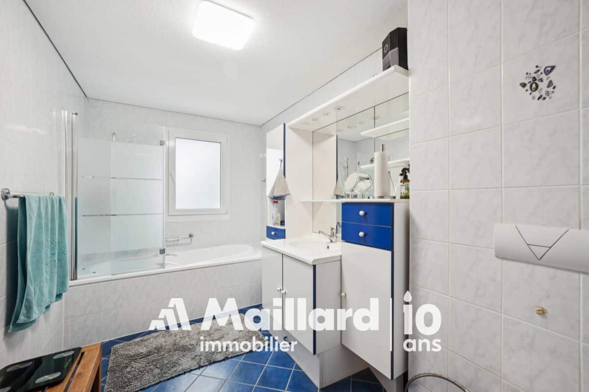 Modernes Badezimmer mit Badewanne und blau-weißen Möbeln