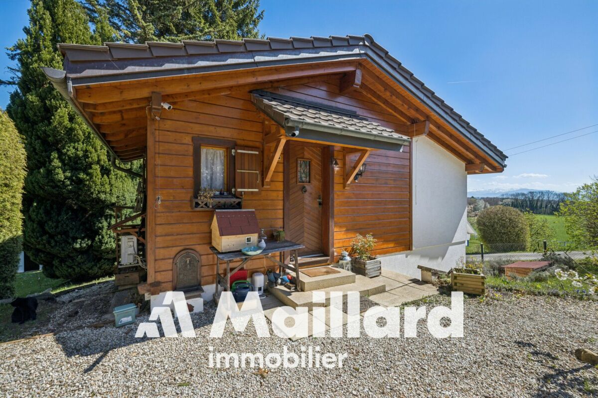 Holzhaus mit Satteldach und Garten
