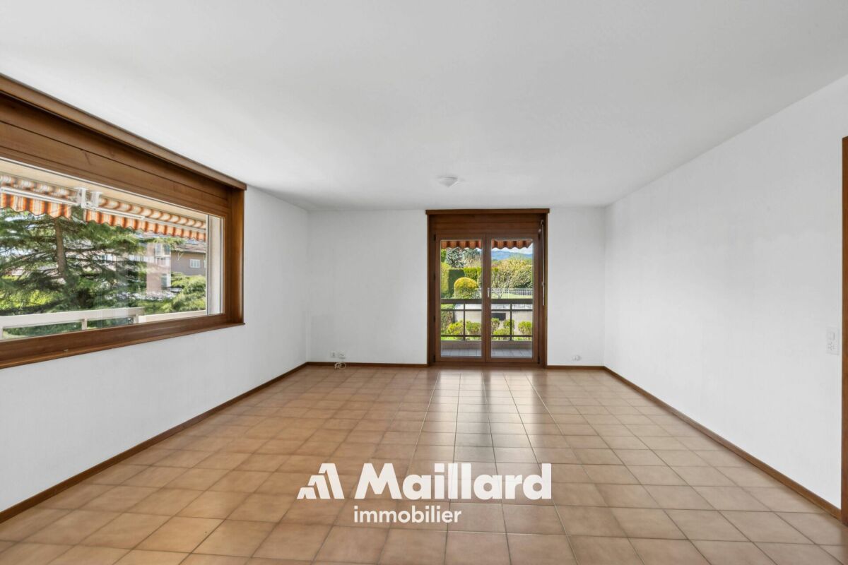 Heller leerer Raum mit Balkon- bzw. Terrassentür und großem Fenster