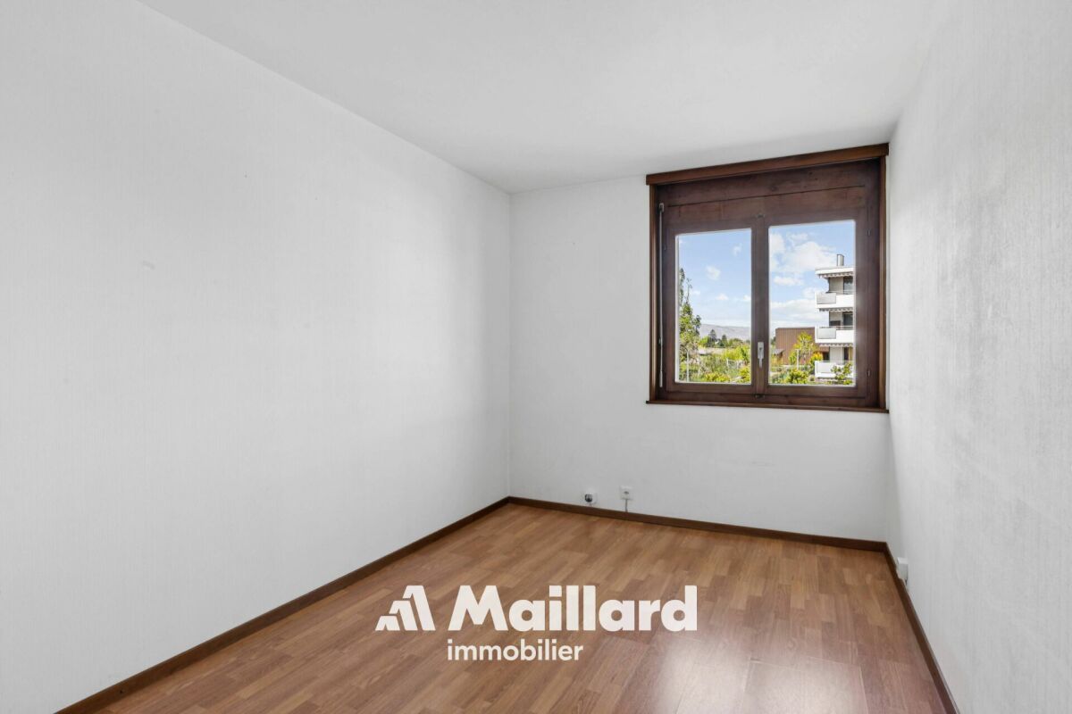 Leeres Zimmer mit Fenster und Holzoptik-Boden