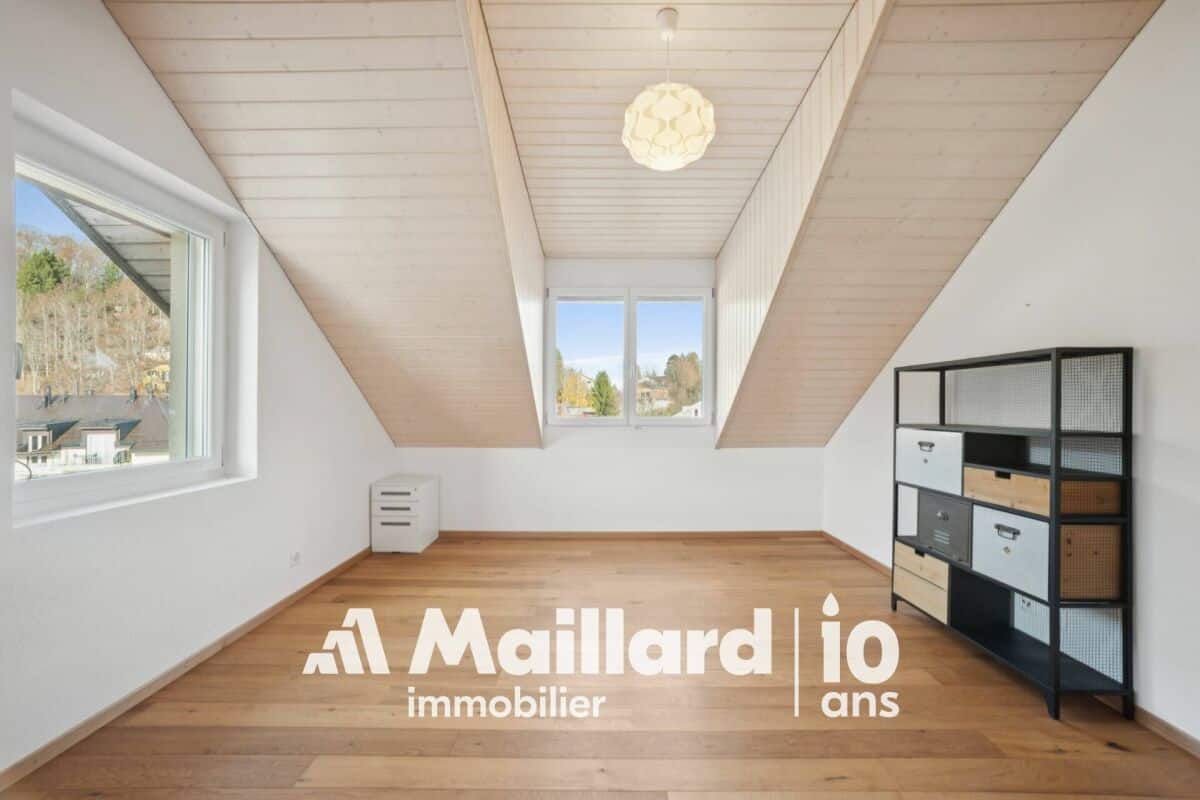 Ausgebautes Dachzimmer mit Holzbalkenoptik