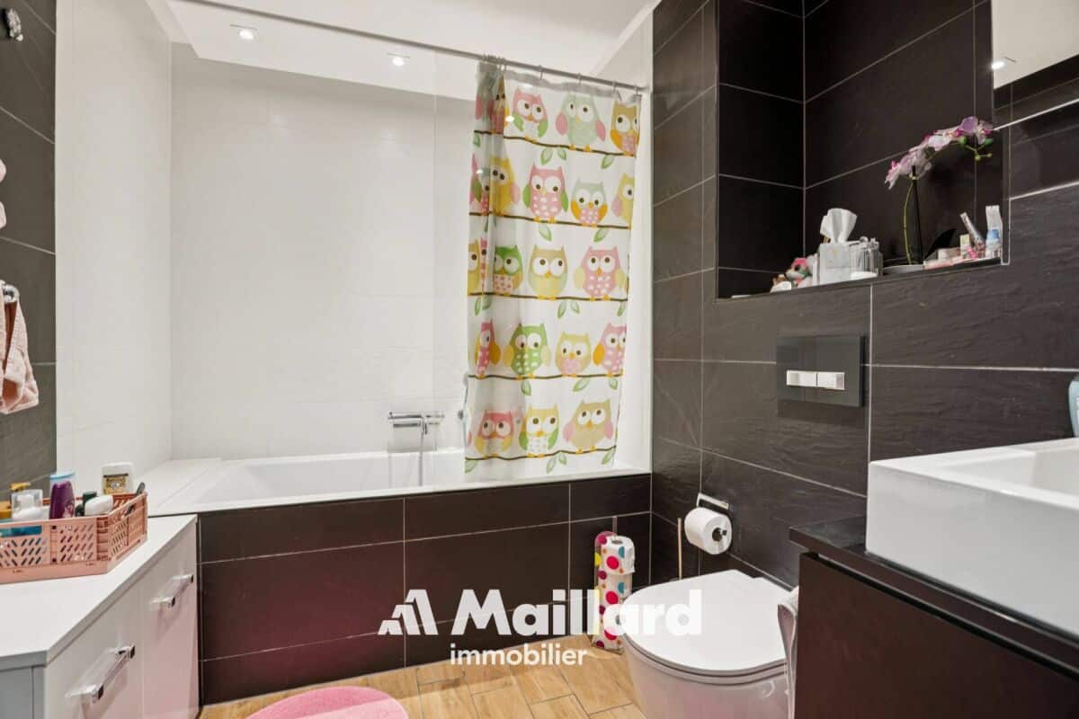 Modernes Badezimmer mit Badewanne und dunklen Fliesen